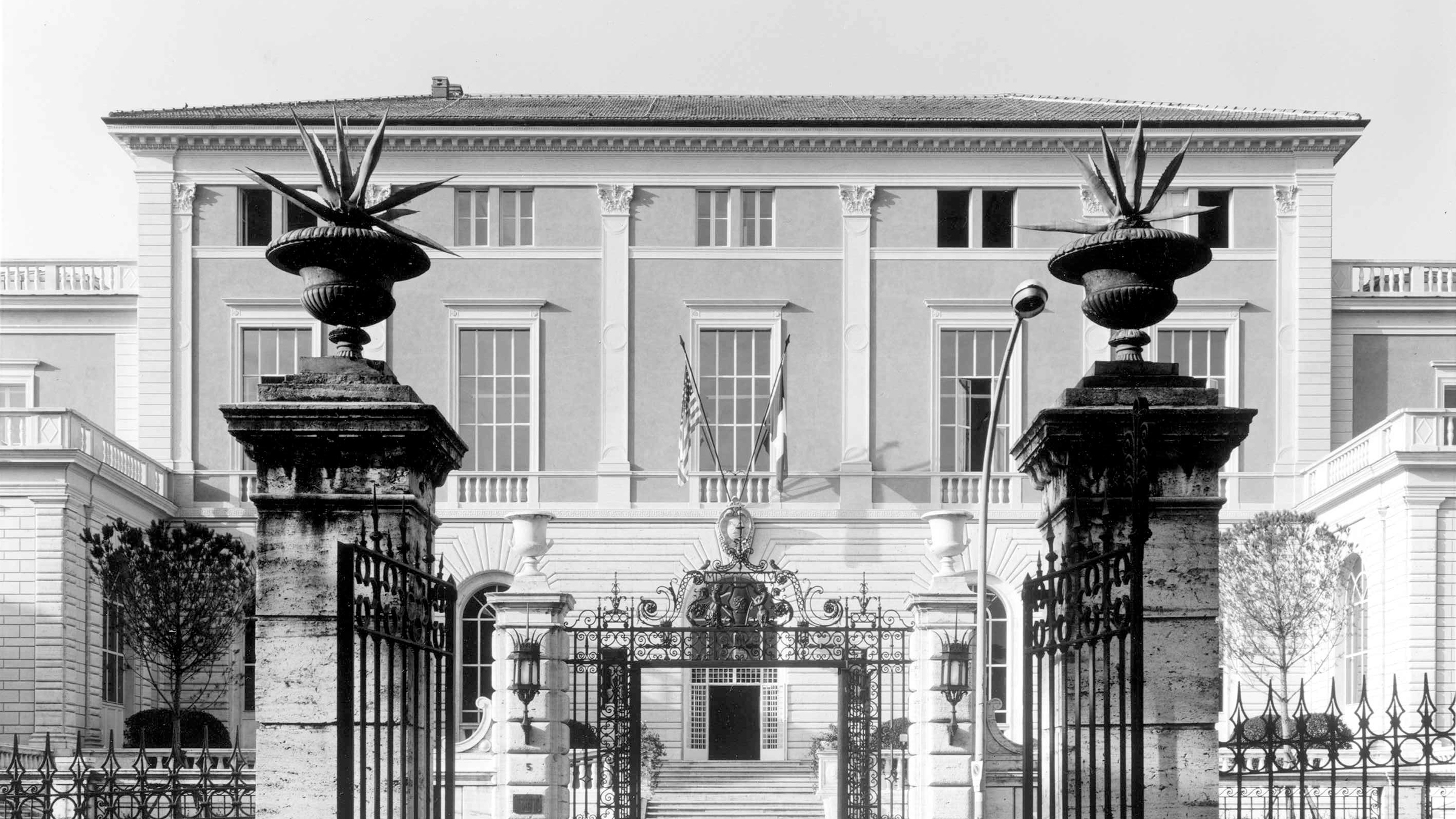 Black and white facade of a neoclassical building and gates