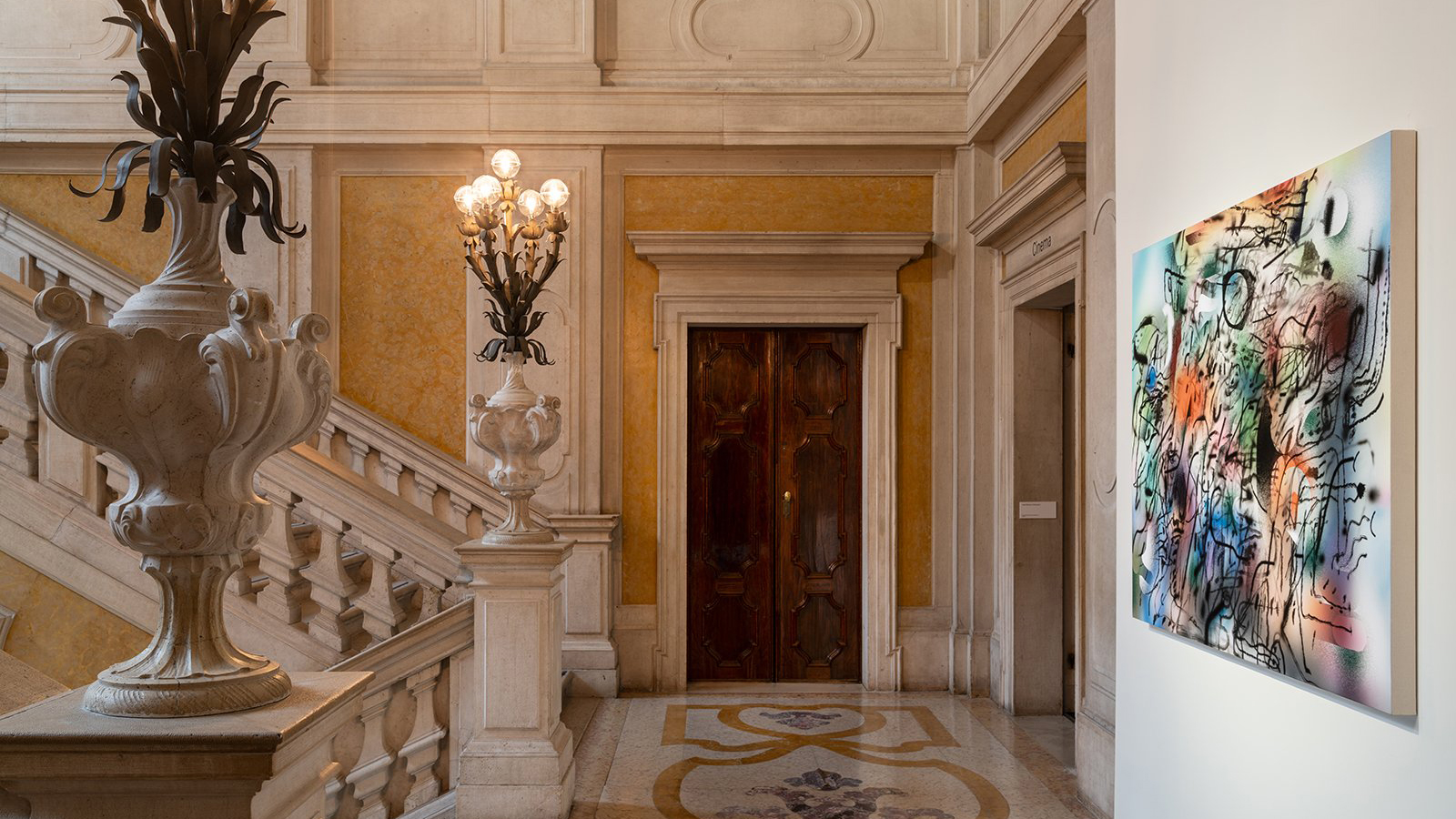 Color photo of a staircase landing in an Italian palazzo with an abstract painting on one wall