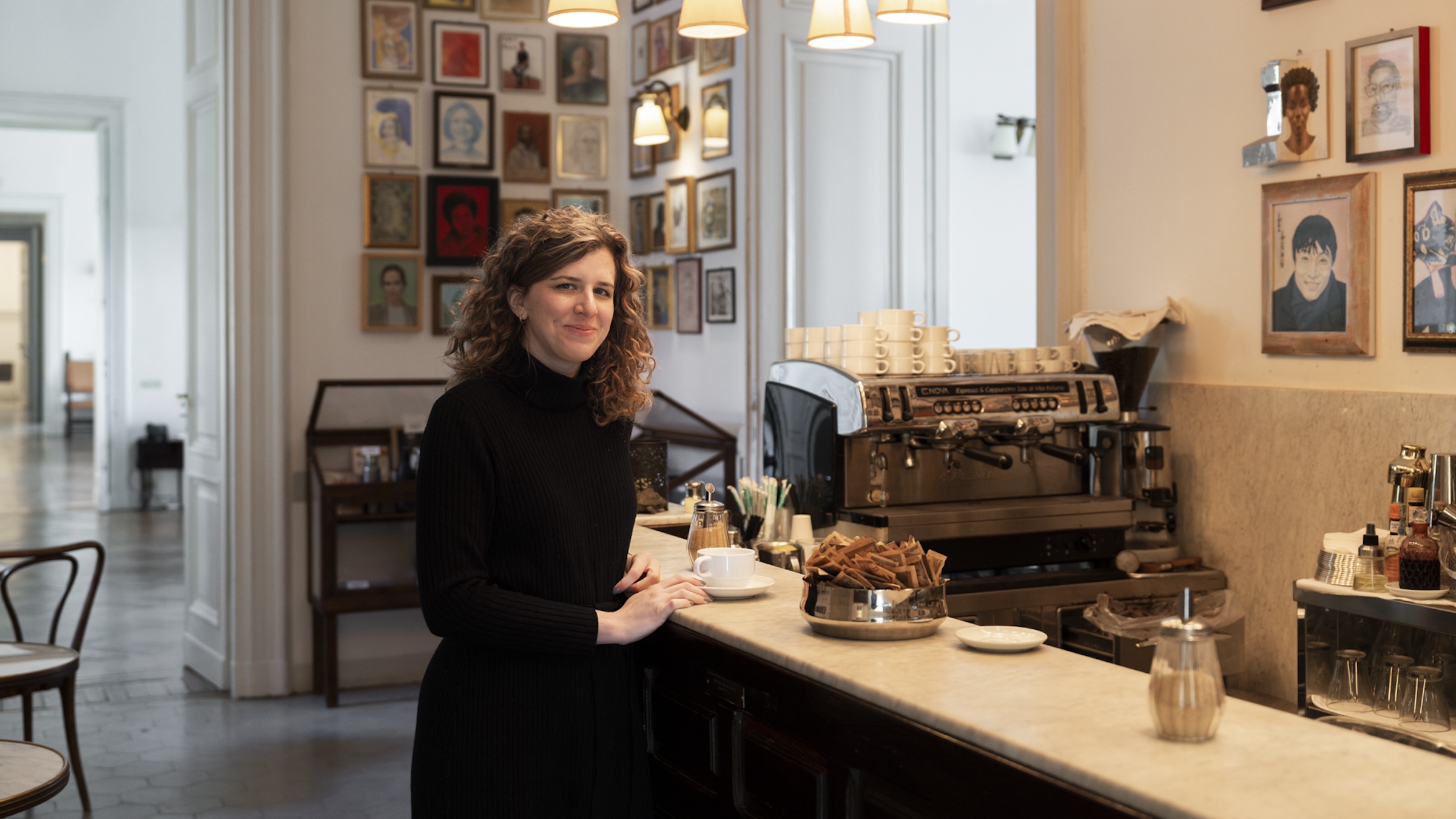 A woman sits at a coffee bar