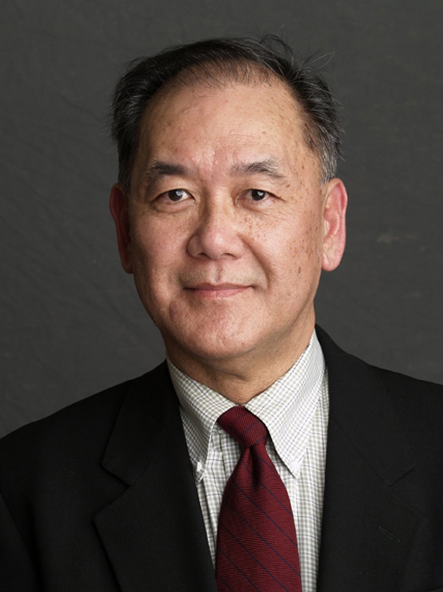 Dennis Y Ichiyama Color photograph of the head and chest of an Asian man wearing a dark suit and smiling at the camera