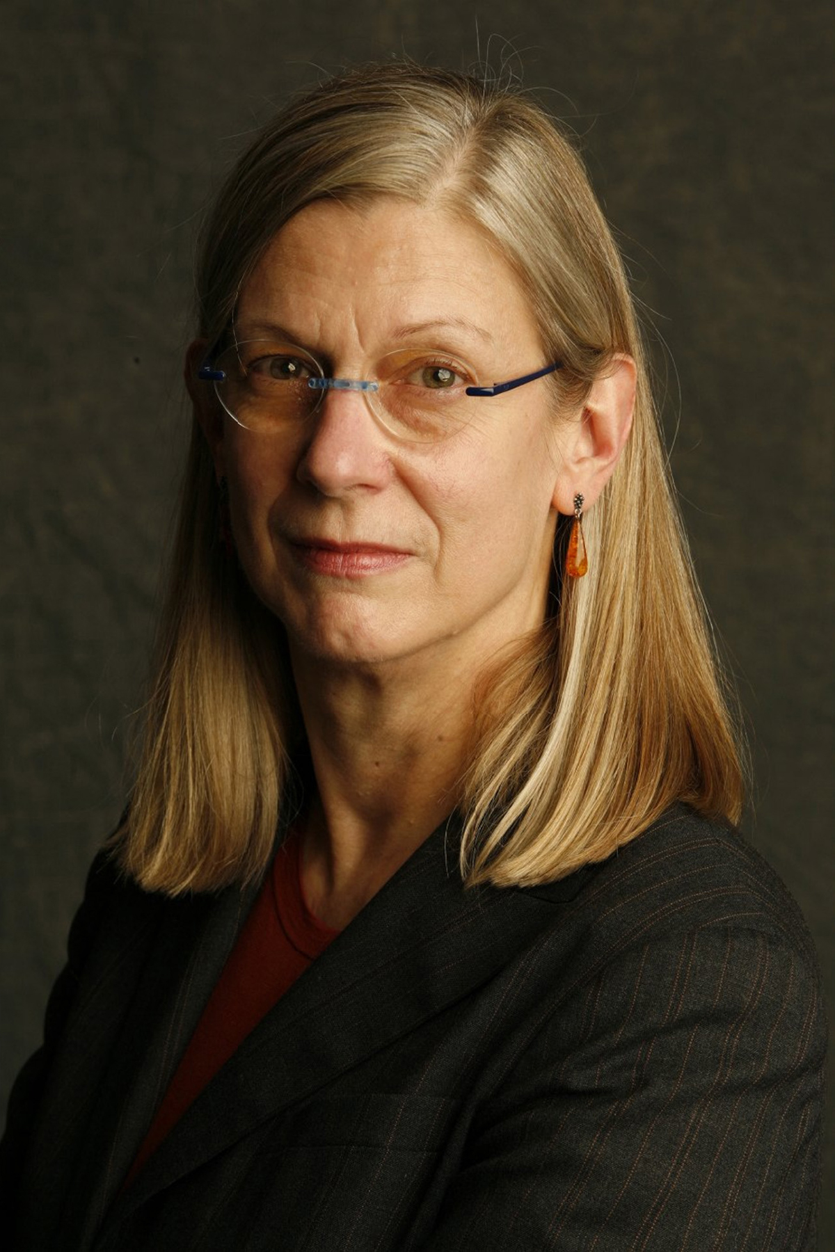 Marjorie Curry Woods Color photograph of the head and shoulders of a light skinned woman with blond hair and glasses looking directly at the camera