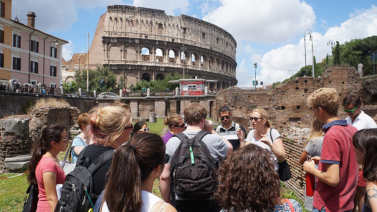 Participants in the Classical Summer School receive a lecture outside the Roman Colosseum