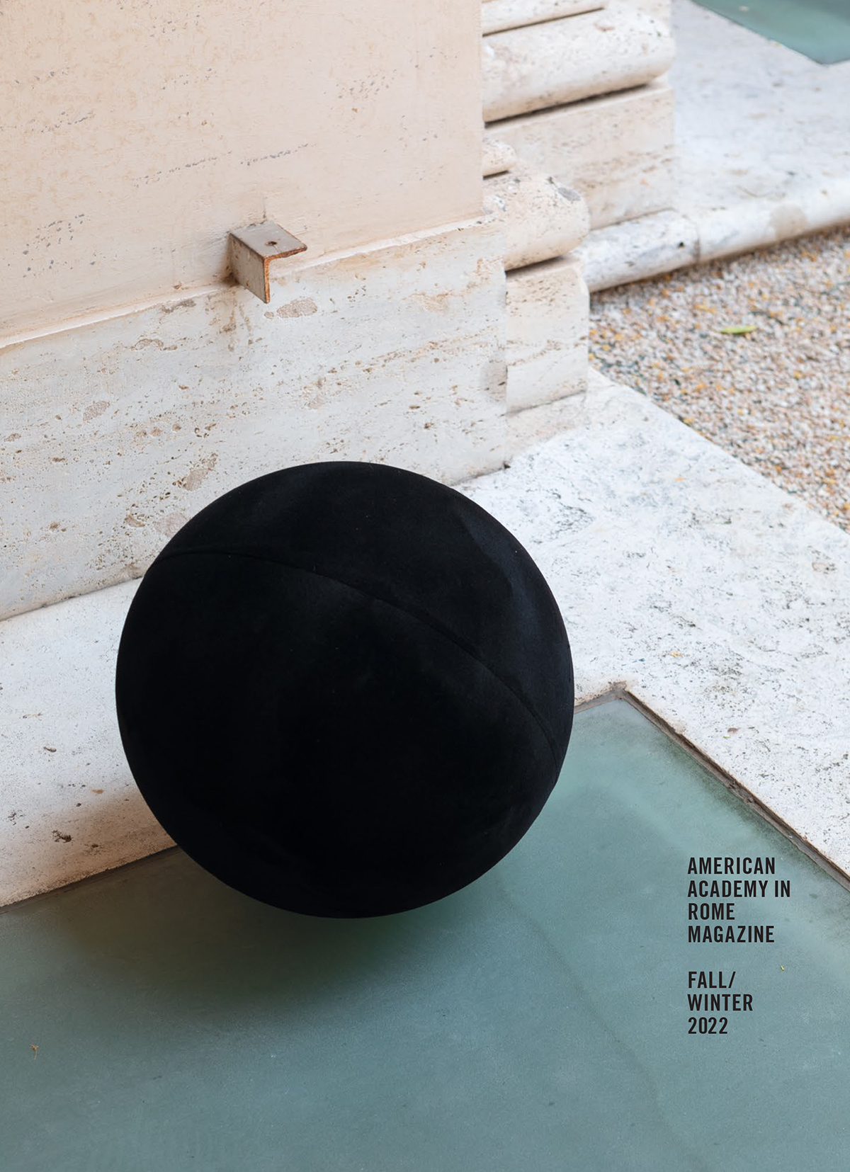 Magazine cover with a color photograph that depicts a sculpture by William Villalongo consisting of a black ball placed on a frosted green basement skylight next to an architectural pillar in the Academy's courtyard