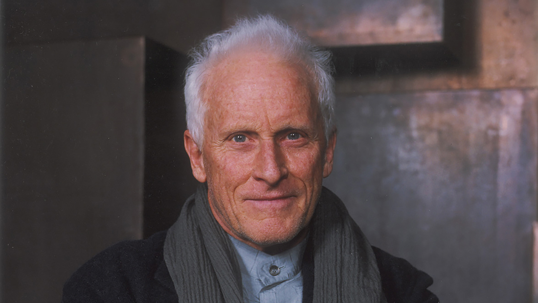 Color photograph of an older, light skinned man looking at the camera