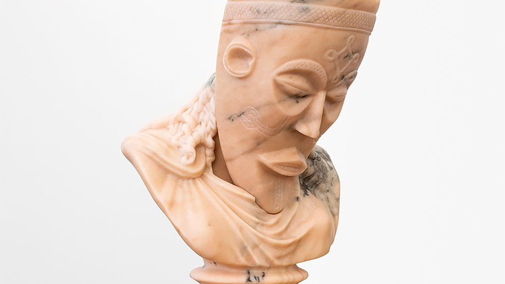 Color photo of a pink marble bust showing an african mask on a Roman-looking neck and shoulders