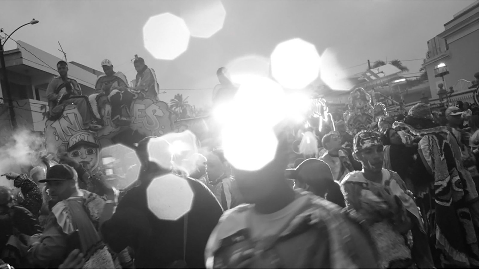 Blurry black and white photograph of people dressed in costumes for a parade