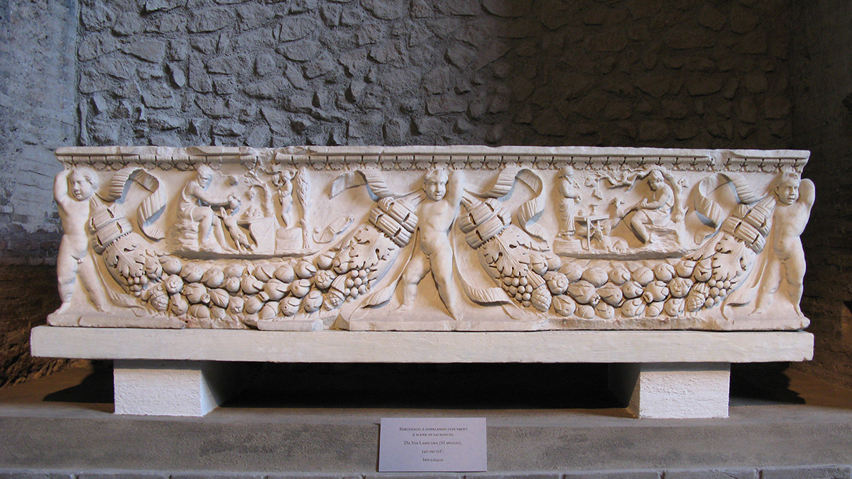 Color photograph of an ancient Roman sarcophagous with carved cupids and cornocopia on the long side