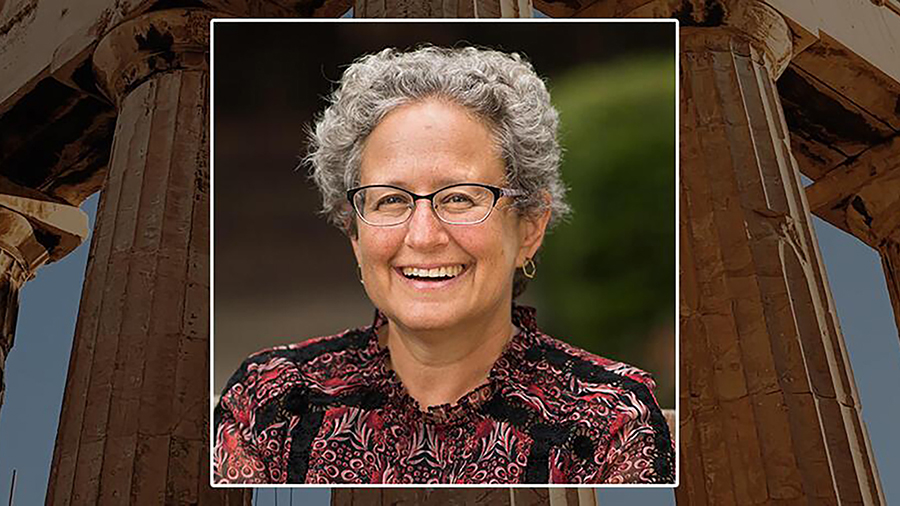 Composite image of a headshot of a light skinned gray haired woman smiling at the camera overlaid on a photograph of the ruins of an ancient greek temple