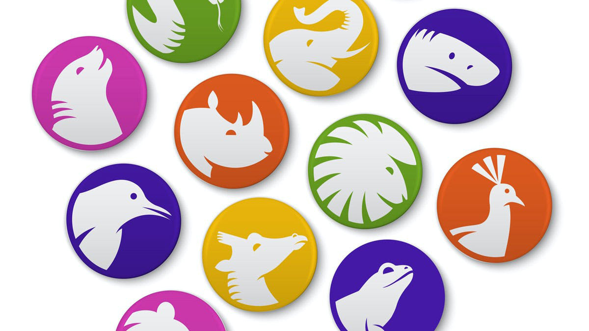 Several colorful round buttons with the profile of various animals in white