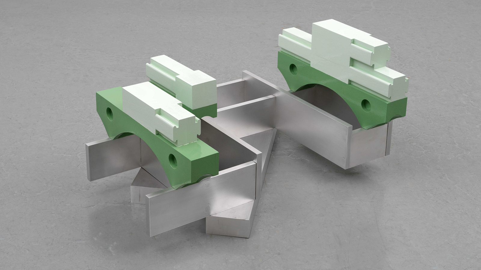 Color photograph of an angular, architectural floor sculpture made of green-painted cherry wood and aluminum