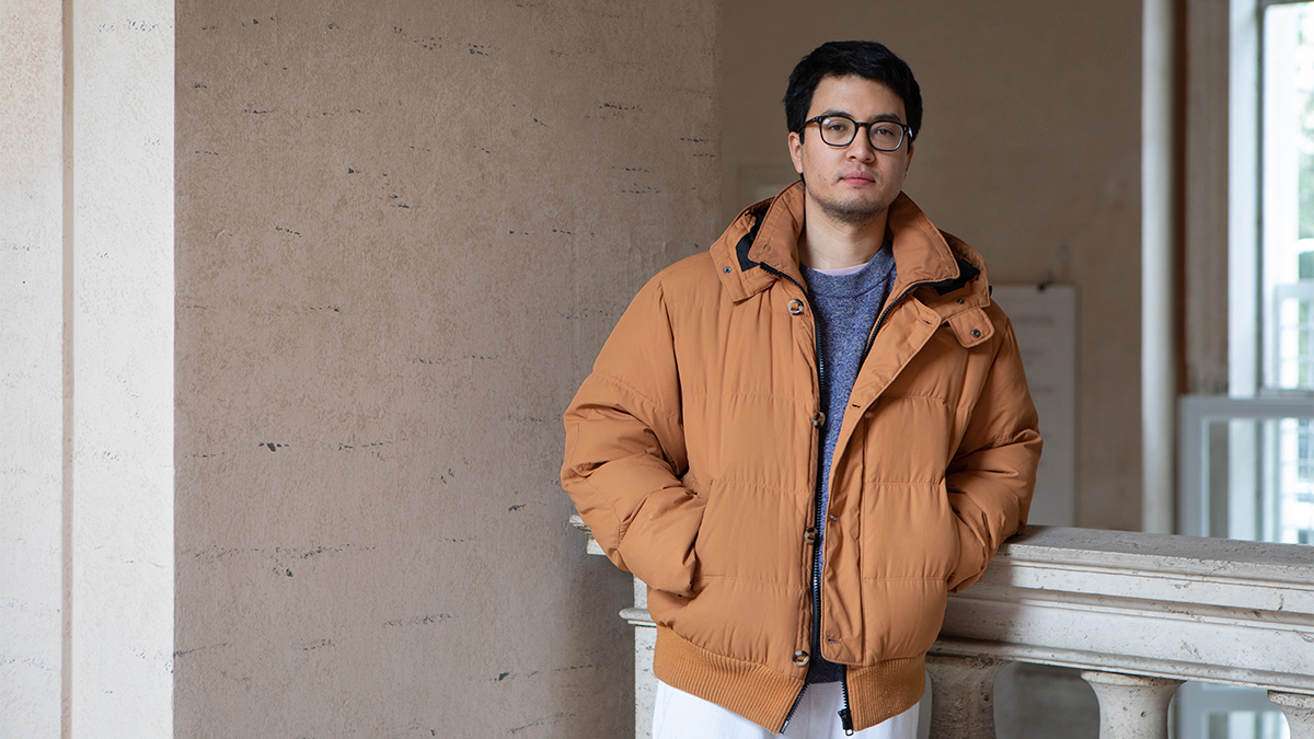 Color photo of an asian man wearing a sandy orange jacket