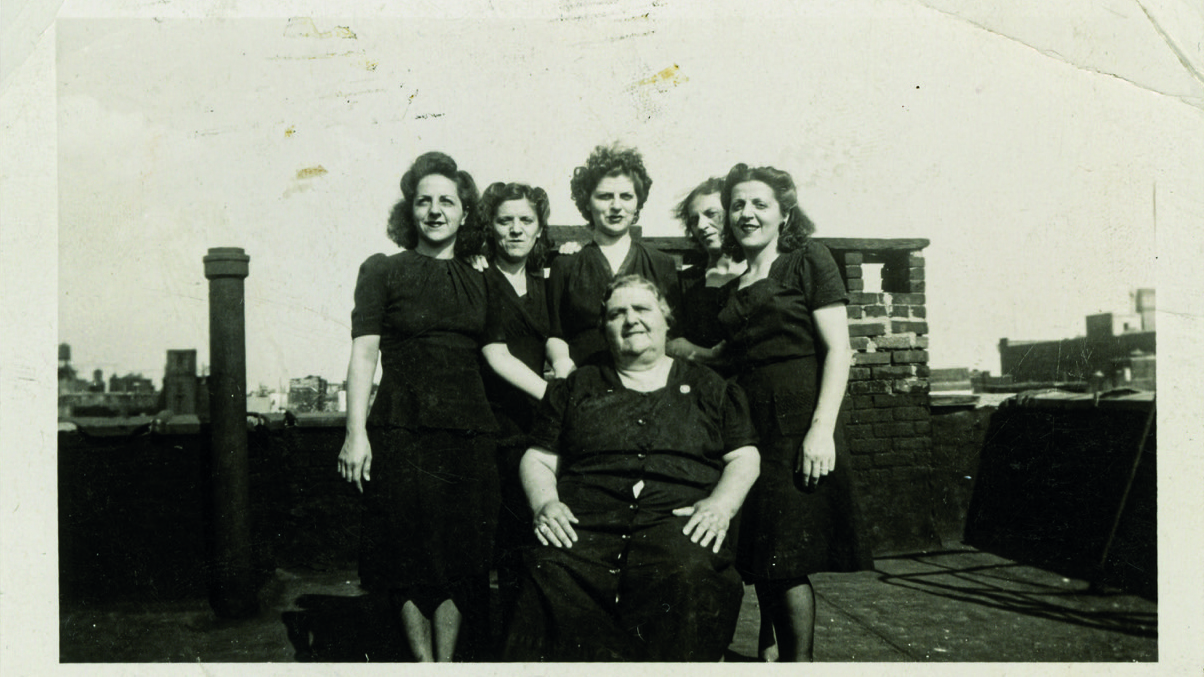Black and white photo of six women (five standing, one sitting) on a rooftop in New York in 1944