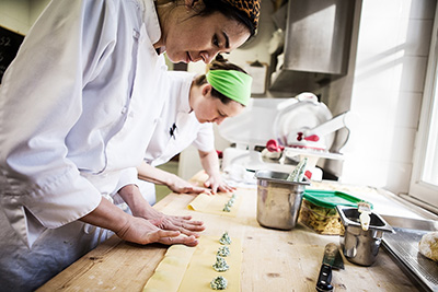 Color photograph of two chef preparing ravioli at the Rome Sustainable Food Project