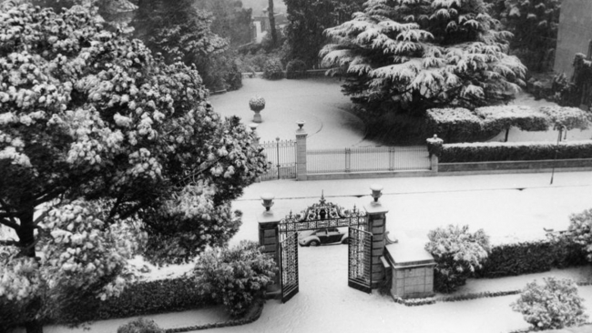 Black and white photograph of a courtyard, street, and garden in Rome covered in snow, as seen from the roof of a building