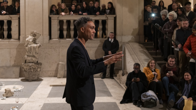 Man gesticulates to a crowd