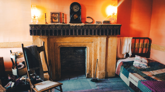 Color photograph of a re-creation of a nineteenth-century tenement apartment showing period furniture, fireplace, and mantle