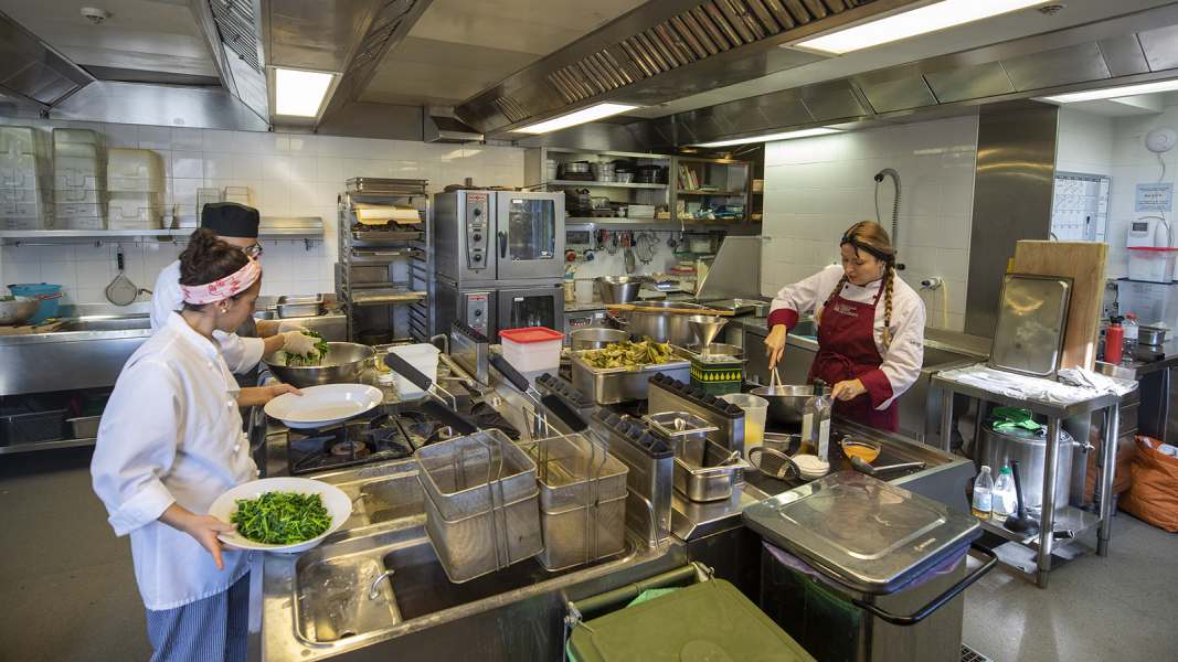 Color photographs of three chefs (two women and one man) preparing food in an institutional kitchen